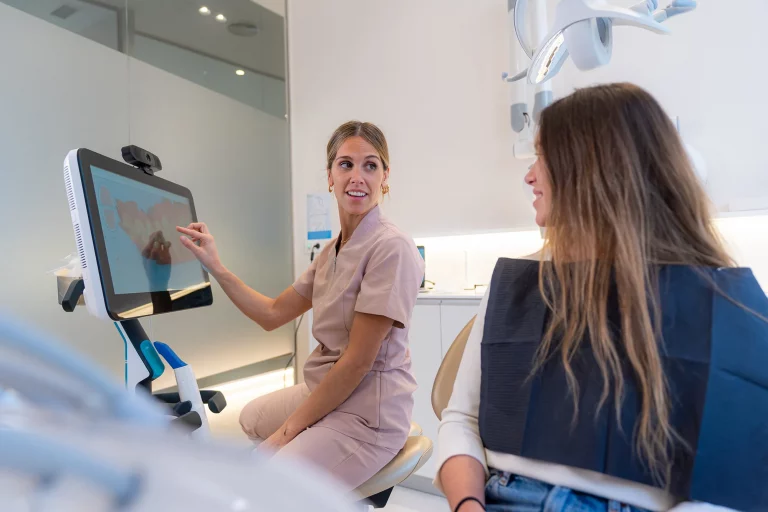 Patient und Kieferorthopäde betrachten gemeinsam den digitalen Behandlungsplan auf einem Monitor