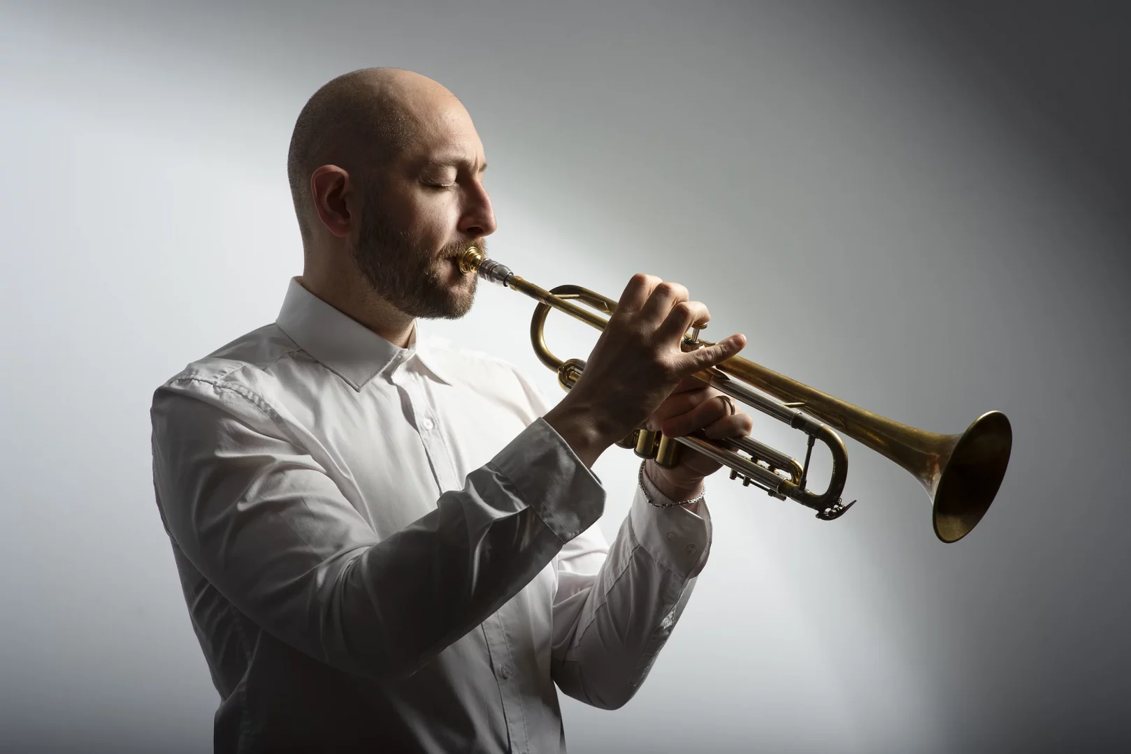 Musiker mit unsichtbarer Lingualspange beim Spielen eines Blasinstruments.