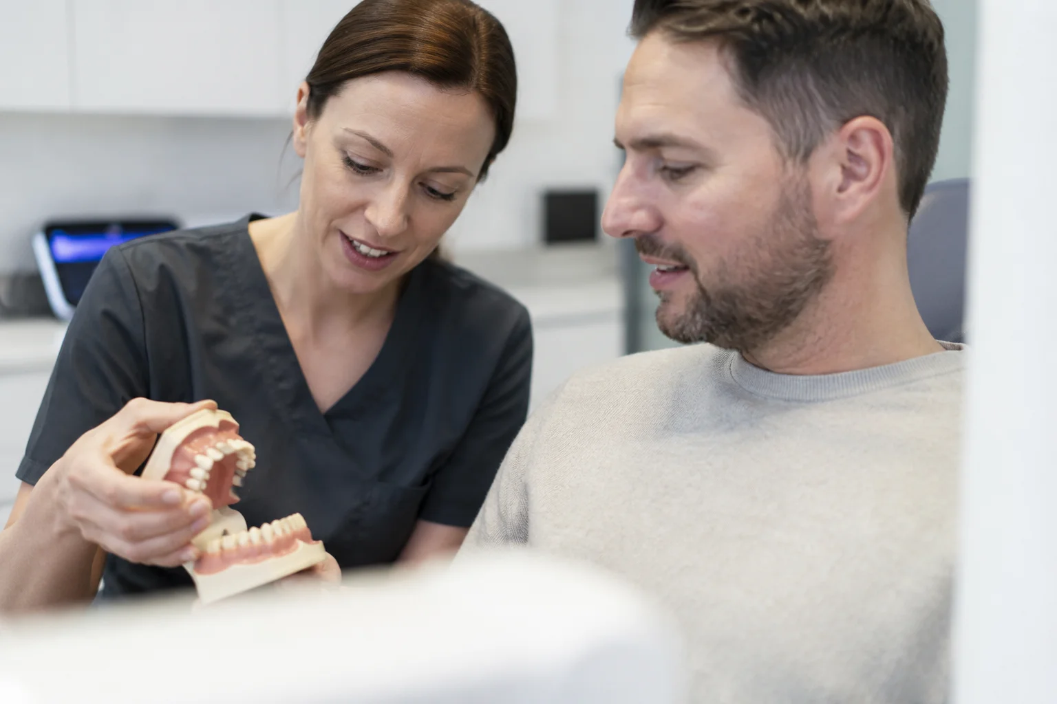 Erwachsener Patient erhält eine Beratung zu einer Zahnkorrektur in einer kieferorthopädischen Fachpraxis.