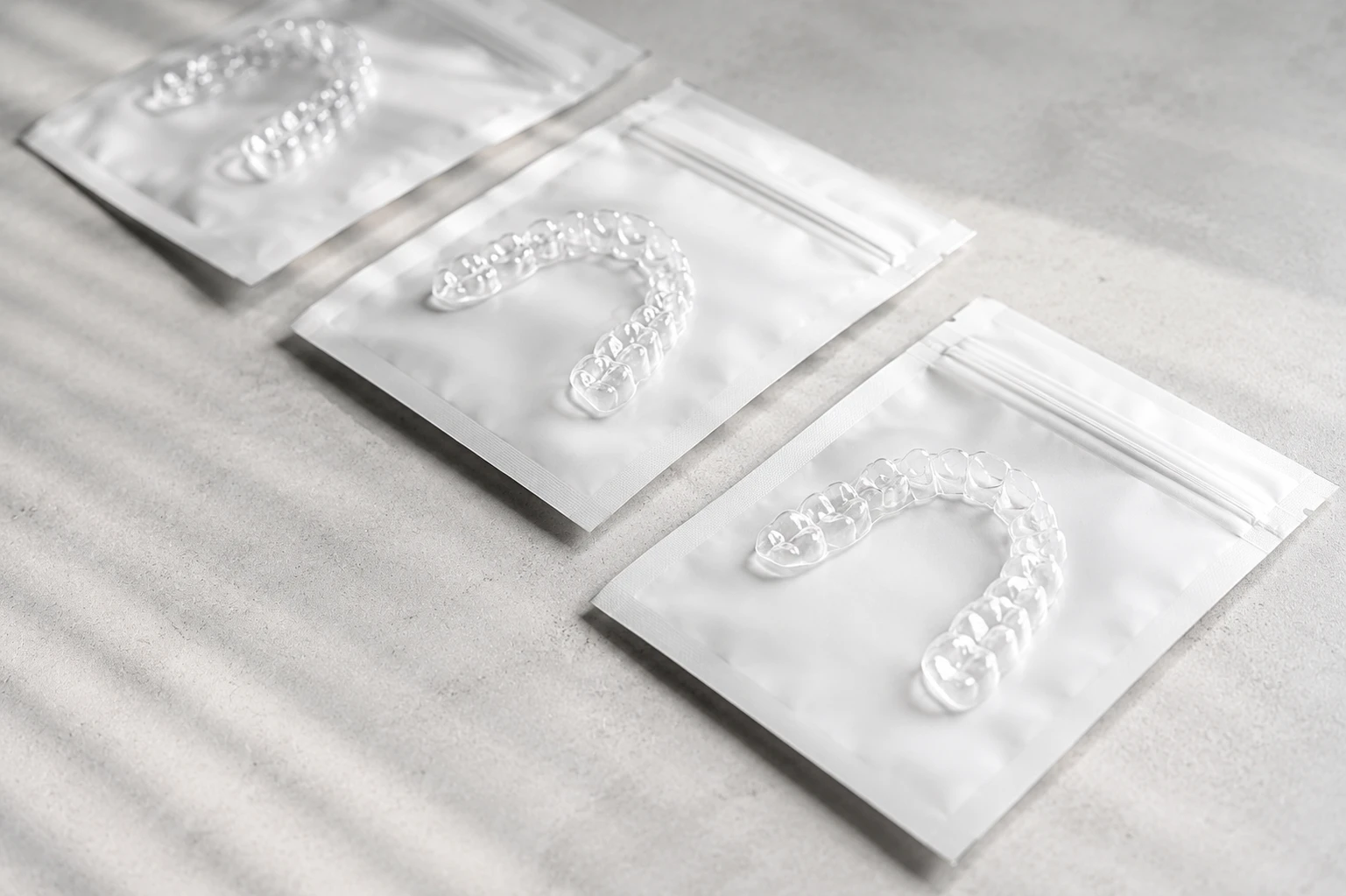 Transparente Aligner-Schienen in hygienischer Einzelverpackung für die Zahnkorrektur.